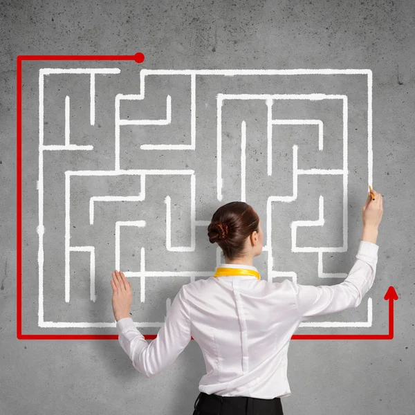 Businesswoman drawing labyrinth — Stock Photo, Image