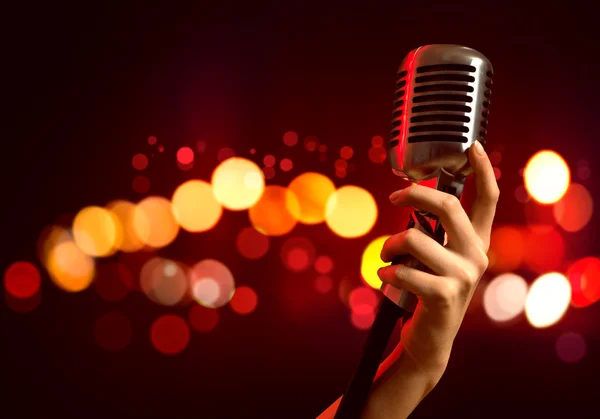 Female hand holding microphone — Stock Photo, Image