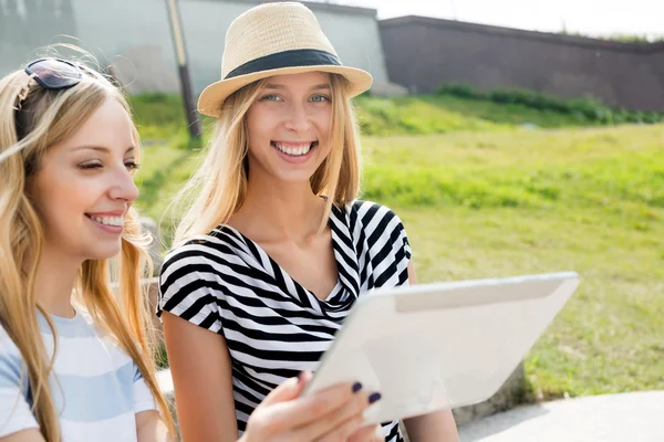 Female friends using device — Stock Photo, Image