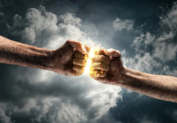 Fists hitting over dramatic sky — Stock Photo, Image