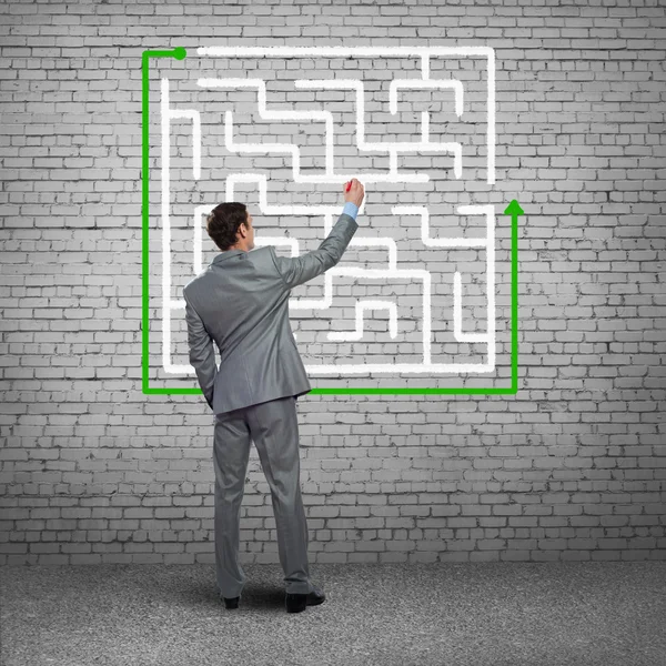 Businessman drawing labyrinth on wall — Stock Photo, Image