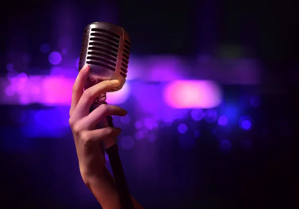 Mão feminina com microfone — Fotografia de Stock