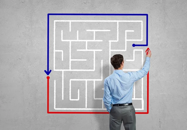 Businessman drawing labyrinth — Stock Photo, Image