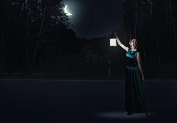 Женщина в зеленом платье с фонарем — стоковое фото