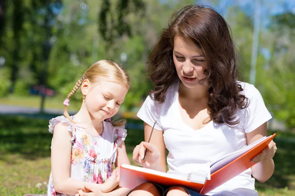 Flicka och kvinna läsa bok — Stockfoto