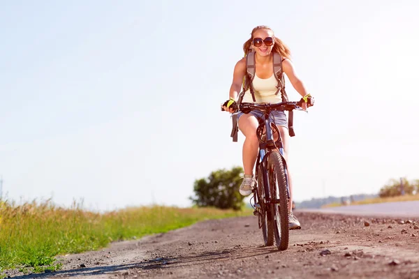 Frau mit Rucksack auf Fahrrad unterwegs — Stockfoto