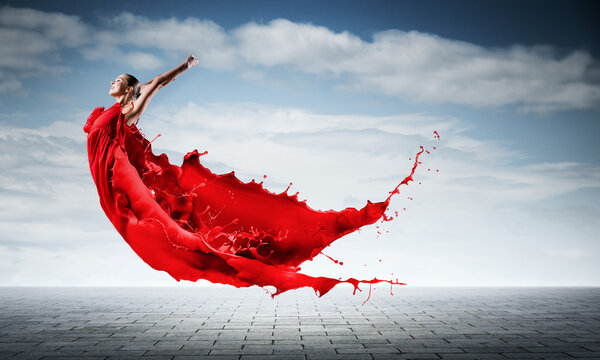 Passionate woman dancer in red dress and red splashes