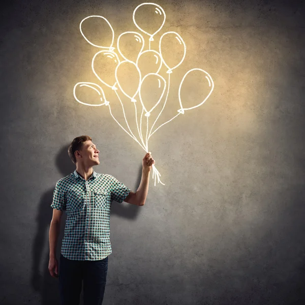 Young man with drawn balloons — Stock Photo, Image