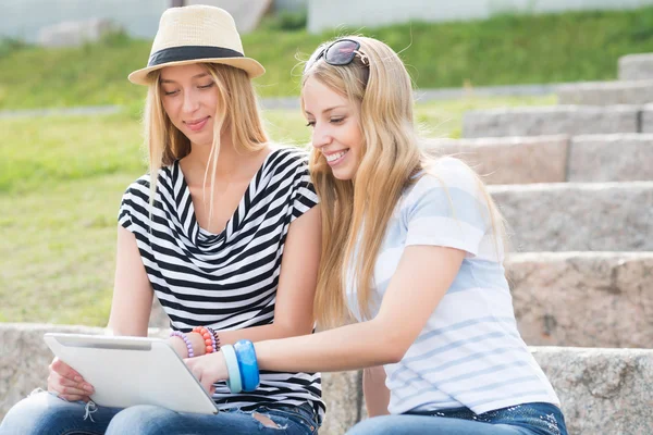 Amigos do sexo feminino usando tablet — Fotografia de Stock