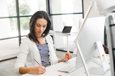 bilgisayarda çalışan esmer kadın