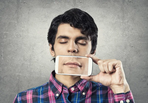 Joven sosteniendo teléfono inteligente — Foto de Stock