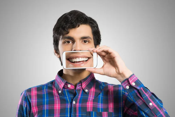 Joven sosteniendo teléfono inteligente — Foto de Stock