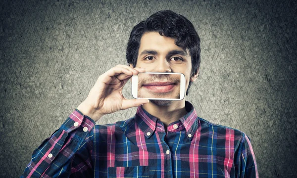 Joven sosteniendo teléfono inteligente — Foto de Stock