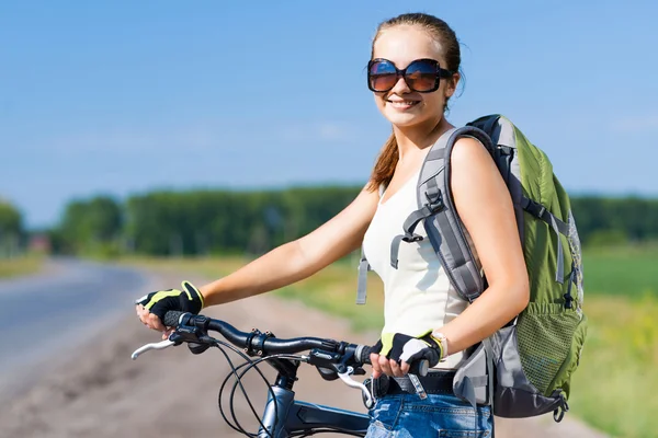 Frau mit Rucksack auf Fahrrad unterwegs — Stockfoto