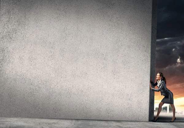 Businesswoman  moving cement wall — Stock Photo, Image