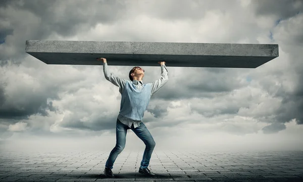 Boy lifting stone wall — Stock Photo, Image