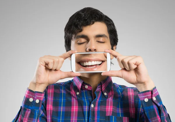 Joven sosteniendo teléfono inteligente — Foto de Stock