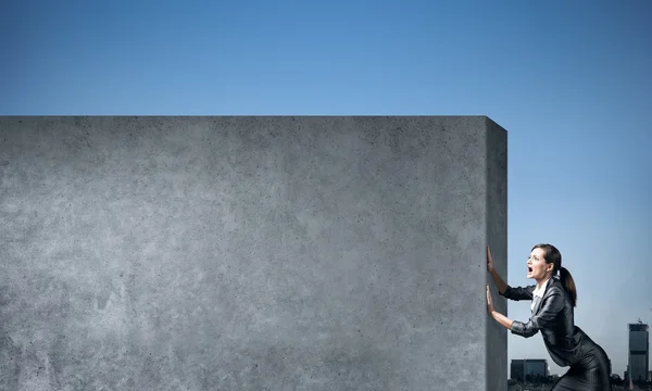 Businesswoman  moving cement wall — Stock Photo, Image