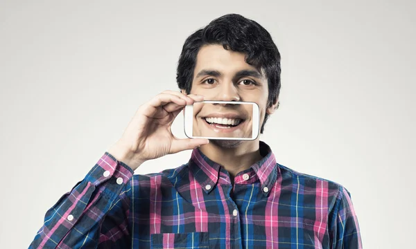 Joven sosteniendo teléfono inteligente — Foto de Stock