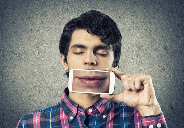 Joven sosteniendo teléfono inteligente — Foto de Stock