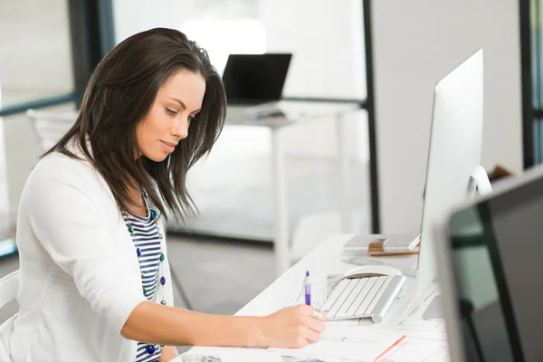 Brunette vrouw die werkt op computer — Stockfoto