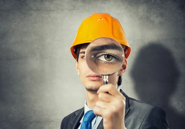 Engineer looking through magnifying glass — Stock Photo, Image