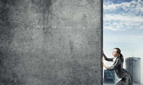 Businesswoman  moving cement wall — Stock Photo, Image