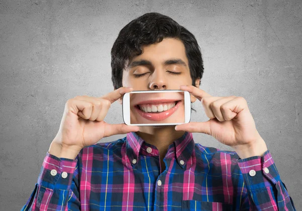 Joven sosteniendo teléfono inteligente — Foto de Stock