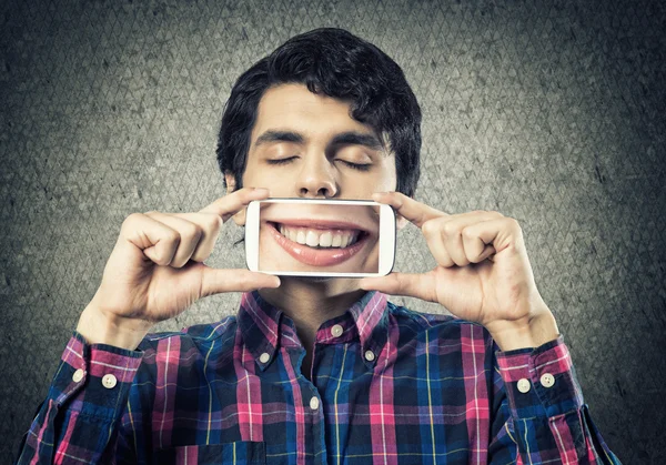 Joven sosteniendo teléfono inteligente — Foto de Stock