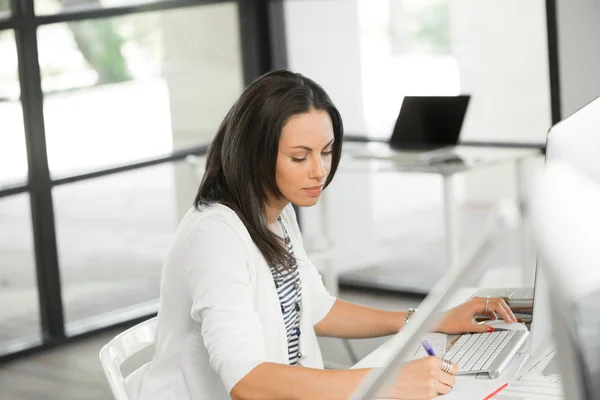 Brunette vrouw die werkt op computer — Stockfoto