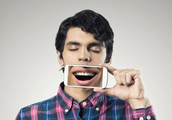 Joven sosteniendo teléfono inteligente — Foto de Stock