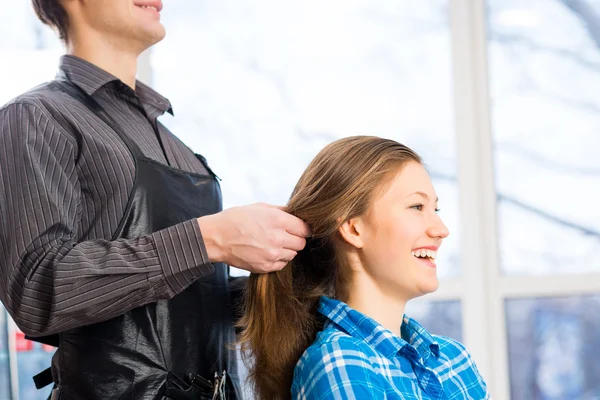 Male hairdresser puts woman's hair — Stock Photo, Image