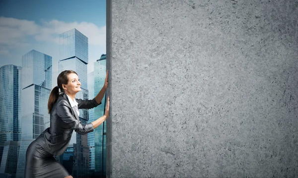 Businesswoman  moving cement wall — Stock Photo, Image