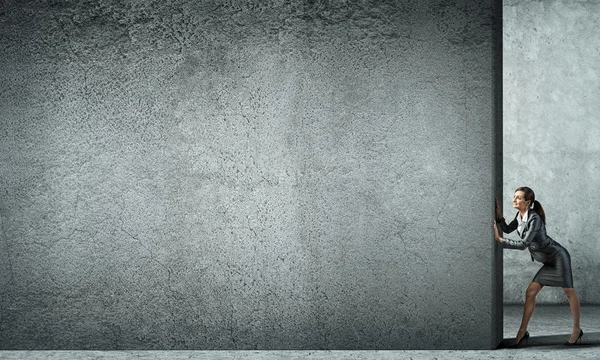 Businesswoman  moving cement wall — Stock Photo, Image