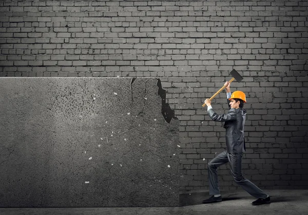 Businessman in helmet breaking wall — Stock Photo, Image