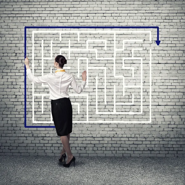 Businesswoman drawing labyrinth — Stock Photo, Image