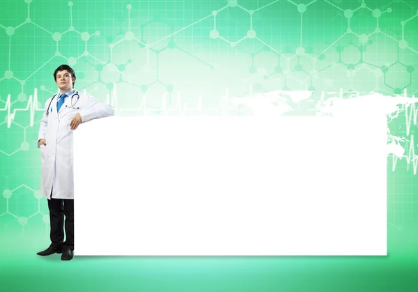 Guapo doctor con banner en blanco — Foto de Stock