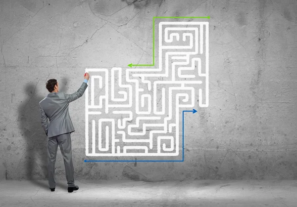 Businessman drawing labyrinth — Stock Photo, Image