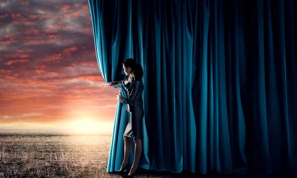 Woman in business suit opening curtain — Stock Photo, Image