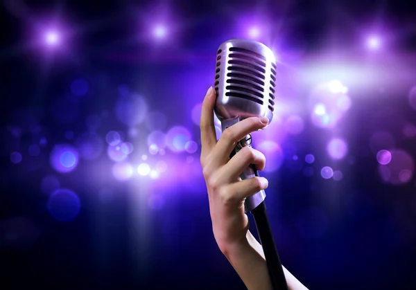 Female hand holding microphone — Stock Photo, Image