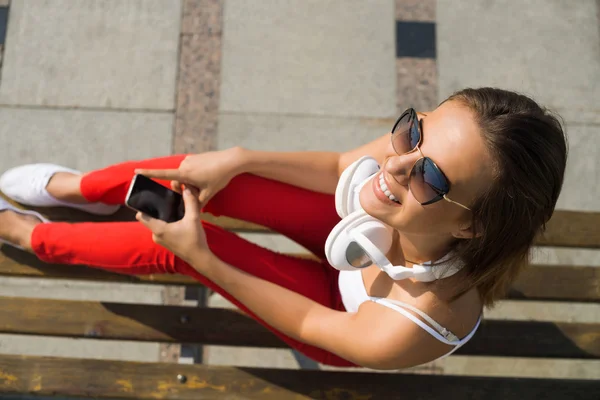 Brunetka s mobilním telefonem — Stock fotografie