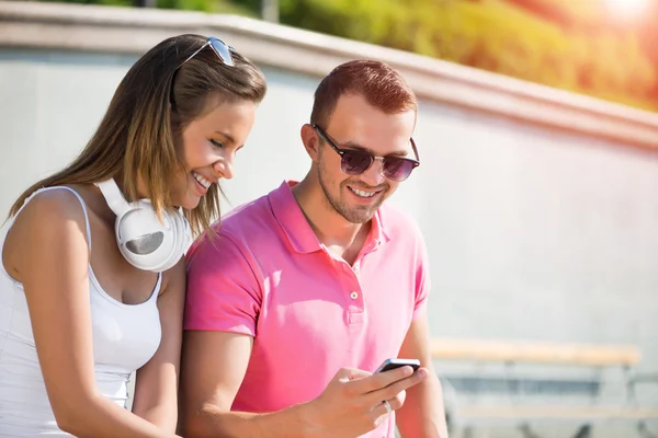 Lächelndes Paar mit Smartphone — Stockfoto