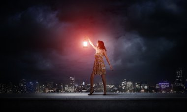 Fener ile yeşil elbiseli kadın