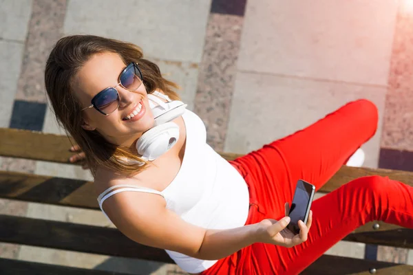 Půvabná brunetka s mobilním telefonem — Stock fotografie