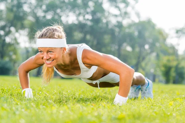 Vrouw doet push ups in park — Stockfoto