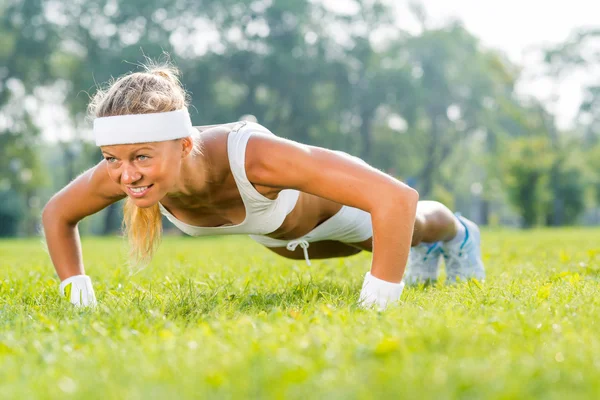 Kadının yapması Push ups parkta — Stok fotoğraf