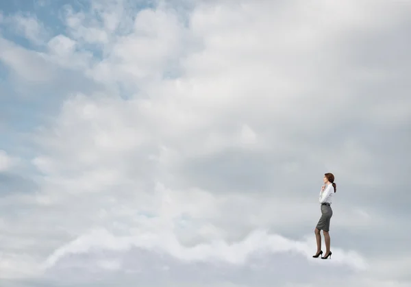 Empresária de pé em nuvens — Fotografia de Stock