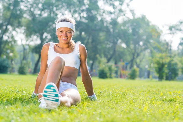 Fitness flicka sitter i park — Stockfoto