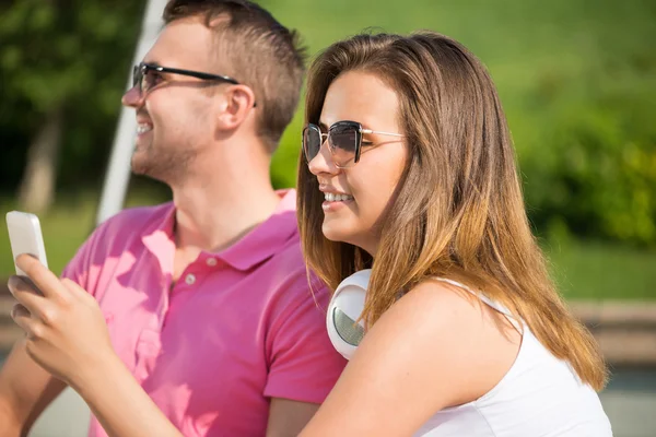 Smiling couple using smartphone — Stock Photo, Image