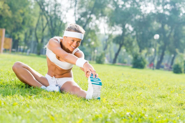 Fitness girl stretching in park — Stock Photo, Image